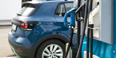 Electric car on gas station. Blue car and electric plug for char