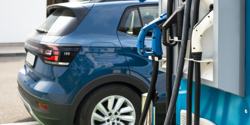 Electric car on gas station. Blue car and electric plug for char