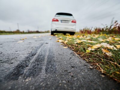 Emergency braking of white car on road outside city.